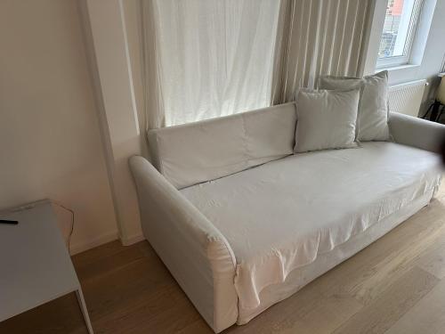 ein weißes Sofa in einem Zimmer mit Fenster in der Unterkunft Apartment in Sollentuna Centrum 1205 in Sollentuna