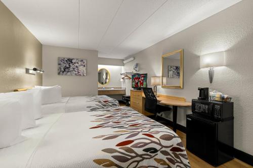 ein Hotelzimmer mit einem Bett und einem Schreibtisch in der Unterkunft Red Roof Inn Salem in Salem