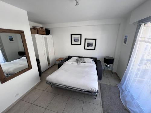 a small bedroom with a bed and a mirror at Riviera Eden Palace in Cannes