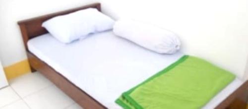 - un petit lit avec 2 oreillers dans l'établissement OYO 93286 Yellow House Syariah, à Bogor