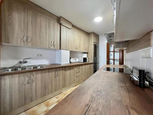 a kitchen with wooden cabinets and a wooden floor at VIVIENDA REAL CON ENCANTO in Úbeda