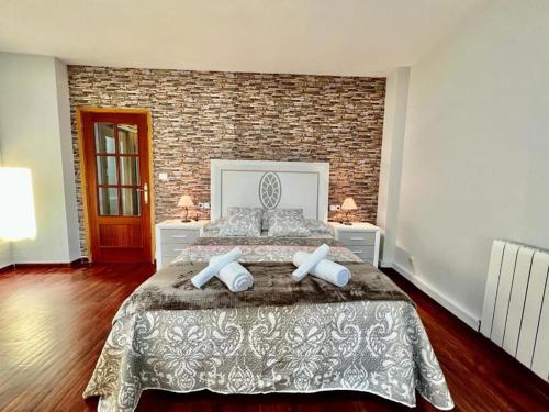 a bedroom with a large bed and a brick wall at VIVIENDA REAL CON ENCANTO in Úbeda