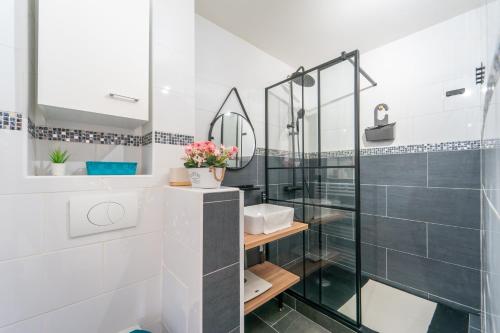 a bathroom with a glass shower and a sink at Sunrise - Bel apt 2 chambres in LʼHay-les-Roses