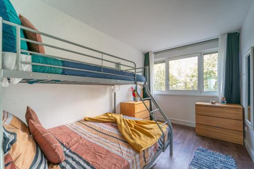 een slaapkamer met een stapelbed en een raam bij Sunrise - Bel apt 2 chambres in LʼHay-les-Roses