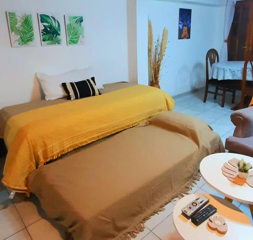 1 dormitorio con 1 cama con manta amarilla en CASA CÉNTRICA, Patio con Parrilla Zona Residencial, Parking privado gratis a 100 mts en Mendoza