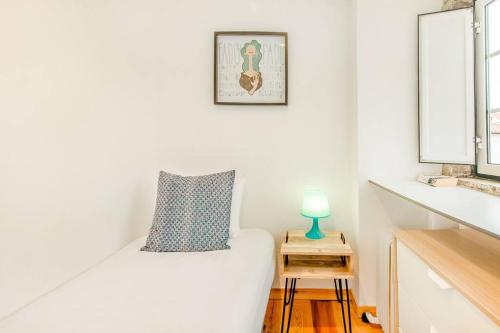 リスボンにあるAlfama Charming Apartmentの白い部屋(ベッド1台、テーブル付)