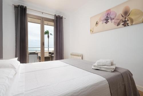 um quarto com uma cama branca e vista para o oceano em Antic 101 em S'illot