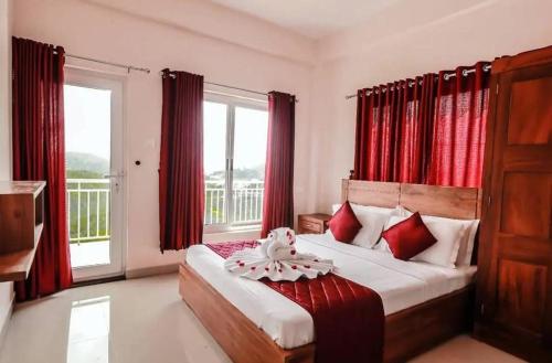 瓦戈曼的住宿－towersky hill resort CONCERN OF PINKY HOLIDAYS，一间卧室配有红色窗帘的床