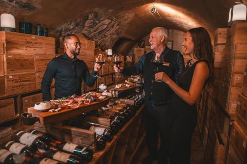 a man and a woman holding glasses of wine at Les Violettes Hotel & Spa in Jungholtz