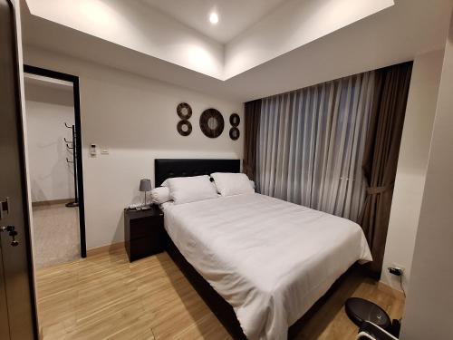 1 dormitorio con 1 cama blanca grande y espejo en Moslem Friendly 1BR Branz BSD, Near AEON Mall & ICE, en Samporo