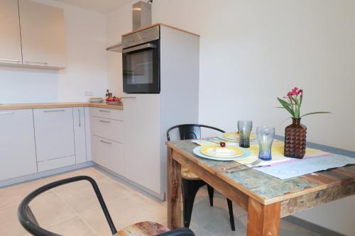a small kitchen with a wooden table and chairs at Goldener Löwe in Bodman-Ludwigshafen