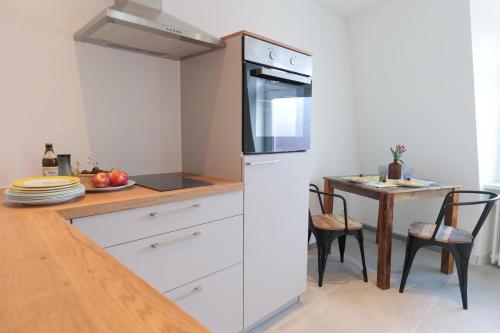 a kitchen with a counter and a table with chairs at Goldener Löwe in Bodman-Ludwigshafen
