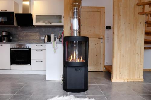 a kitchen with a stove with a fire in it at Almdorf Hohentauern by ALPS RESORTS in Hohentauern