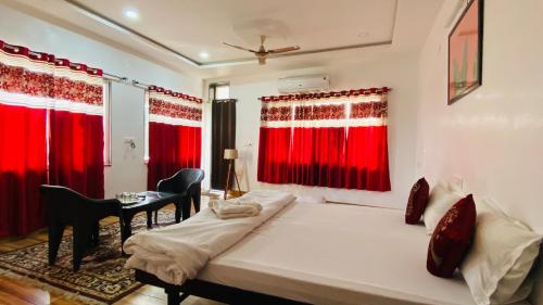 a bedroom with two beds and red curtains at Hotel Lake Star in Udaipur
