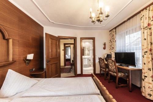 a hotel room with a bed and a desk at Hotel Elisabeth in Schoppernau