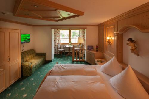 a hotel room with a bed and a living room at Hotel Elisabeth in Schoppernau