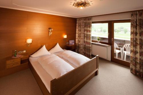 a bedroom with a large bed with a window at Hotel Elisabeth in Schoppernau