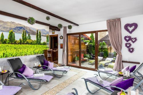 a patio with purple chairs and a view of a vineyard at Hilson Jasna - Garden resort in Liptovský Mikuláš