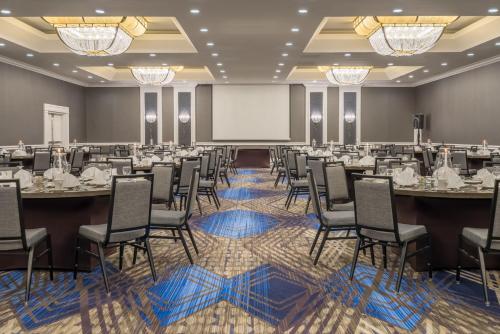 a conference room with tables and chairs and a projection screen at Crowne Plaza Annapolis by IHG in Annapolis