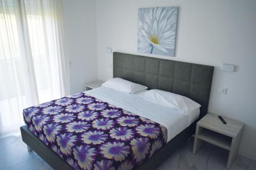 um quarto com uma cama com uma fotografia de flores na parede em Residence La Magnolia - Aparments em Lazise