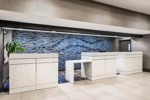 a lobby with a white counter and a tile wall at Crowne Plaza Annapolis by IHG in Annapolis