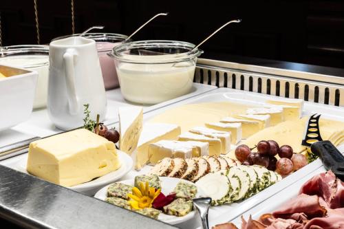 a tray of cheese and other foods on a table at Hotel Elisabeth in Schoppernau