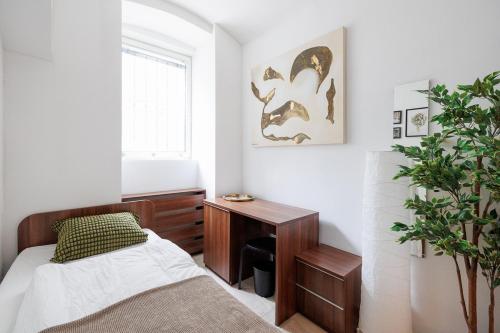 a bedroom with a bed and a desk and a plant at Vienna City Business Rooms in Vienna