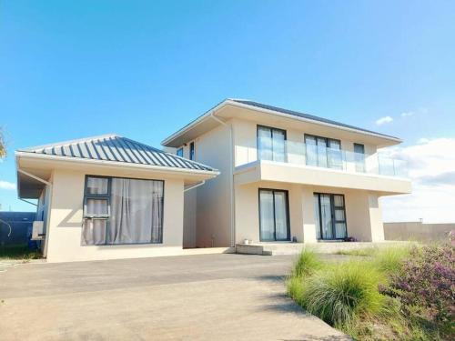 a large white house with a solar roof at Ocean Views & Stunning Sunsets 1st-Floor Villa in Flic-en-Flac