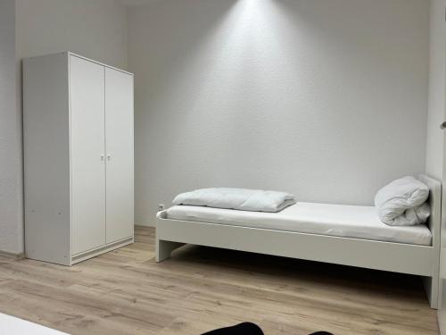 1 dormitorio blanco con 1 cama y armario en Hannover 24 S, en Hannover