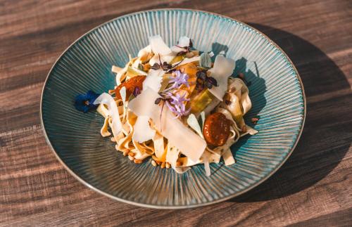 a blue plate of food on a wooden table at Les Violettes Hotel & Spa in Jungholtz