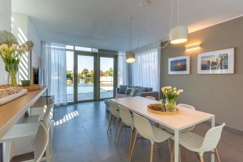 a dining room and living room with a table and chairs at Isola di Albarella in Isola Albarella