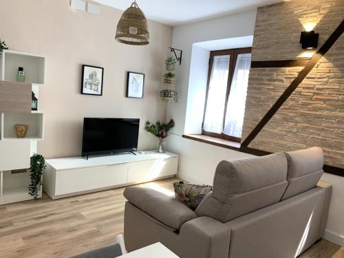 a living room with a couch and a flat screen tv at Casa de los Canteros in Toledo