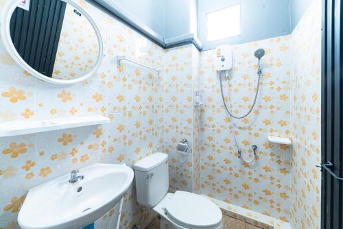 La salle de bains est pourvue de toilettes, d'un lavabo et d'un miroir. dans l'établissement Joox B - Serviced Apartment, à Betong