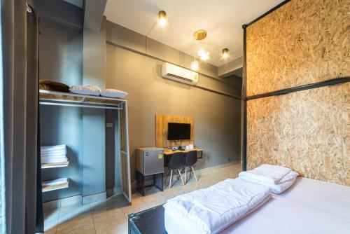Cette chambre comprend un lit et un bureau. dans l'établissement Joox B - Serviced Apartment, à Betong