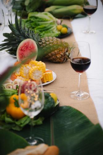 a table with glasses of wine and fruit and vegetables at Suối Camp in Ba Ria