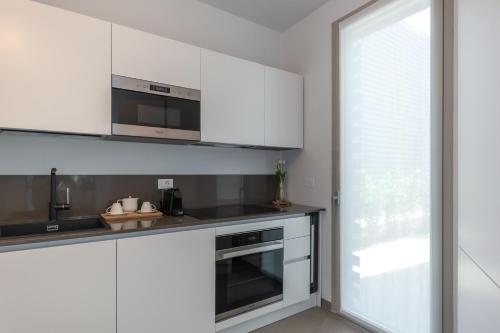 a white kitchen with white cabinets and a window at Isola di Albarella in Isola Albarella