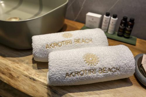 two towels on a wooden cutting board next to a mixer at Akrotiri Beach Resort Hotel - Adult Friendly in Paleokastritsa