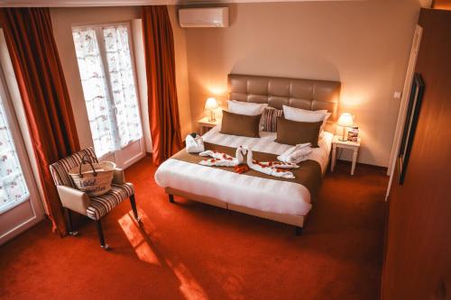 a bedroom with a large bed and a chair at Les Violettes Hotel & Spa in Jungholtz