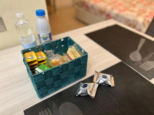 una cesta de comida y botellas de agua en una mesa en Bicocca Flat F, en Milán