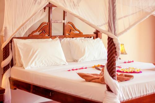 a bed in a room with some decorations on it at Mandarin Resort Zanzibar in Kizimkazi