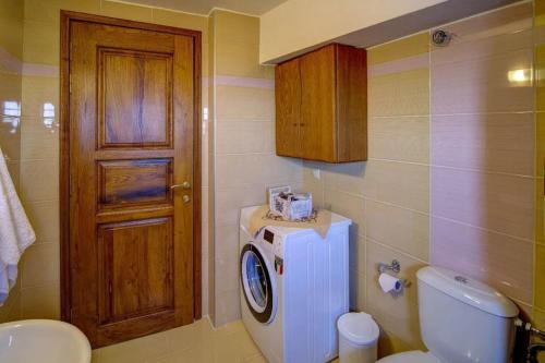 a bathroom with a toilet and a washer at Pileas Pinakates-Milies-Vizitsa in Pinakátai