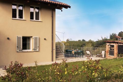 a house with a patio and a table and chairs at I Ciabot di Monforte in Monforte dʼAlba