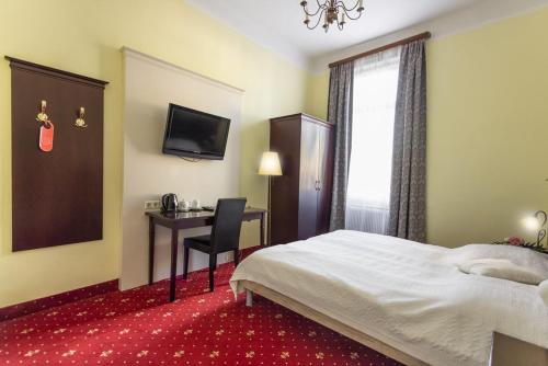 a hotel room with a bed and a desk at Hotel Viktoria Schönbrunn in Vienna