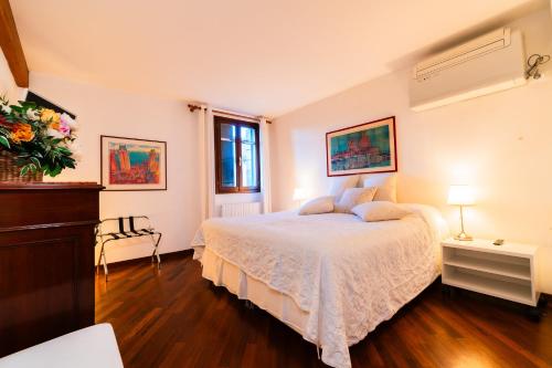 1 dormitorio con 1 cama con colcha blanca en Venice Heaven Apartments - Ca Giulia apartment with private living TERRACE on last floor no lift, en Venecia