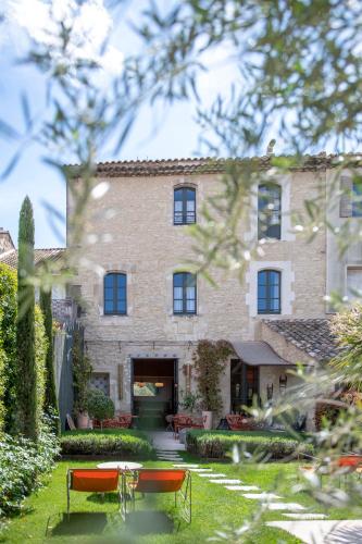 un grande edificio in mattoni con due panchine di fronte di Le petit hotel a Saint-Rémy-de-Provence