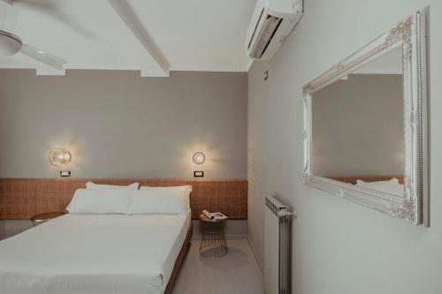 a bedroom with a white bed and a mirror at Hotel Marisa in Rome