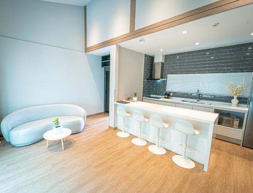 ein Wohnzimmer mit einem Bett und eine Küche in der Unterkunft The Private Hamdeok in Jeju-do