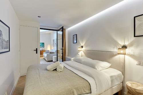 une chambre avec un grand lit avec des draps blancs dans l'établissement Apartment Arc de Triomphe by Studio prestige, à Paris