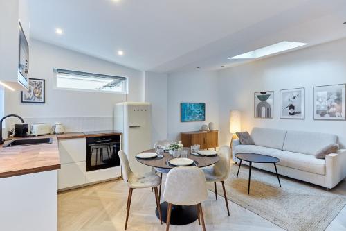 une cuisine et un salon avec une table et un canapé dans l'établissement Apartment Arc de Triomphe by Studio prestige, à Paris