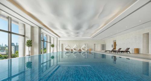 a swimming pool in a building with windows at Shangri-La Nanjing in Nanjing